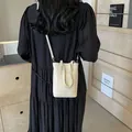 Mini cream leather crossbody phone bag shown on a model in a minimalist style - 15*6*19 / Off White