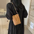 Brown mini crossbody phone bag in pebble grain leather worn by a model in a minimal setting - 15*6*19 / Khaki