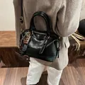 Retro black leather Boston bag with gold hardware and charms on brown wool coat - No Pendant / Black