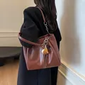 Bolso de hombro en cuero marrón oscuro con pespuntes blancos y colgante decorativo - Estándar / Marrón Caramelo