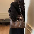Bolso tote de cuero marrón con colgante de béisbol y costuras en la correa al hombro - Estándar / Café