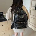 Glossy black padded backpack in space cotton fabric featuring a large front zipper pocket - 30*13*40 / Black