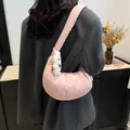 Pink puffy crescent shoulder bag with a cute lamb pendant shown on a model - One Size / Pink