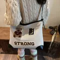 Beigefarbene Canvas-Tragetasche mit Bärenstickerei und schwarzen Lederakzenten - Große Kapazität / Schwarz + brauner Bärenanhänger