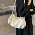Off-white velvet tote bag with pleated texture and plush bear charm worn by a model - Off White