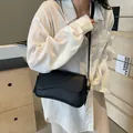 Borsa a tracolla in pelle nera a grana di litchi con base curva e dettagli dorati - Nero