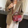 Bolso de mano rojo oscuro con etiqueta de moda llevado cruzado sobre un blazer - Rojo Grande