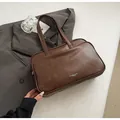 Detail shot of vintage brown synthetic leather texture and printed logo on Boston bag - No Pendant / Brown