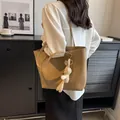 Bolso tote caqui de cuero PU mate con colgante de conejo en modelo en ambiente de casa - Tipo estándar / Caqui