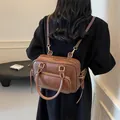 Vintage Damen Rucksack aus braunem Leder mit goldenen Beschlägen an einem Model - 27*12*17 / Braun