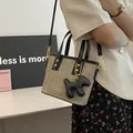Taupefarbene Eimertasche mit Felsstruktur, schwarzen Griffen und Hund-Anhänger - Mit Anhänger Stil / Schwarz und Grau