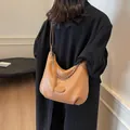 Elegante borsa hobo color cammello con frange e catena argentata indossata su cappotto nero - 29*14*27 / Marrone