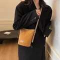 Bolso cubo de ante marrón caramelo con etiqueta de cuero y correa ajustable - Marrón