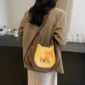 Vintage braune Cord-Tragetasche mit Cartoon-Welpenstickerei am Modell in einem Café - Braun