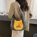 Sac cabas en daim gris foncé avec broderie chat, porté par un mannequin dans un café - Gris