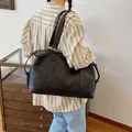 Große schwarze Reisetasche aus weichem PU-Leder, getragen von einem Modell im Studio - Schwarz