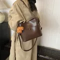 Dunkelbraune Leder-Beuteltasche mit Teddybär-Anhänger und modischem Schriftzug - Schulter-Eimertasche / Kaffeebraun