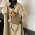 Braune Leder-Eimertasche für Damen mit modischem Anhänger und schmalem Schultergurt - Schulter-Eimertasche / Khaki
