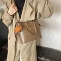 Braune minimalistische Leder-Einkaufstasche mit Teddybär-Anhänger und Gold-Logo - Schulter-Eimertasche / Khaki (Mit Hundeanhänger)