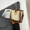 Bolso saco acolchado beige con ribetes de cuero marrón y cierre de giro dorado - Blanco y Marrón