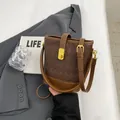 Bolso bombonera trenzado marrón oscuro con herrajes dorados y correa ajustable - Marrón