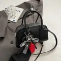 Schwarze Boston-Handtasche mit Anhängern auf grauem Anzug für einen schicken Look - 24*8*13cm / Schwarz + Anhänger
