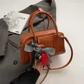 Braune Vintage Boston Handtasche aus glattem Kunstleder mit modischem Anhänger und Tragegurt - 24*8*13cm / Karamell Mit Anhänger