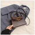 Detail of dark brown Kelly style handbag with gold hardware on a navy blazer - Coffee / 19.5cm x 14cm x 8cm