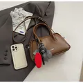 Brown bowling crossbody bag in matte leather featuring trendy decorative charms - With Pendant / Brown