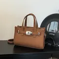 Braune Baguette-Tasche mit Litschistruktur, silbernen Schnallen und Schultergurt - 24.5*10*17 / Karamellbraun
