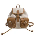 Dettaglio di uno zaino in tela beige con tasche rifinite in pelle marrone scuro - Cachi