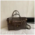 Grote donkerbruine vintage shopper met gouden hardware en verstelbare riem op wit textiel - Bruin