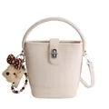 Beige lychee leather bucket bag with dog pendant and adjustable strap in variant view - White With Baseball Charm