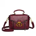 Bolso bandolera de cuero suave rojo oscuro con asa superior y detalles dorados mate - Burdeos