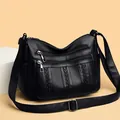Classic black leather crossbody bag with multiple zippers and adjustable strap - Black