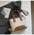 Detalle de bolso tipo cubo de lona con asas de cuero y estampado de moda actual - Blanco Roto