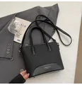 Bolso tipo cubo negro minimalista con acabado mate y correa de hombro ajustable - Negro