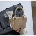 Cream bucket bag with knot handle, gold rings and adjustable strap in lifestyle setting - Standard Type / 21*8*15 / Off White