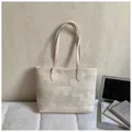 Detail der beigen Canvas-Tote-Bag mit geometrischem Muster und Lederriemen für den Alltag - Gebrochenes Weiß