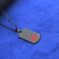 Collier d'alerte médicale noir mat avec symbole étoile de vie rouge sur tissu bleu texturé - Style Noir