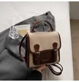 Nahaufnahme des Vintage-Rucksacks in Beige und Braun mit Schnallenklappe und Tragegriff - Standardausführung / Gebrochenes Weiß