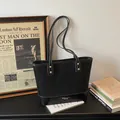 Klassische schwarze Tragetasche mit weißen Kontrastnähten und goldenen Nieten - Schwarz