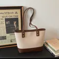 Minimalistische beige Tote-Tasche mit braunem Besatz und goldenen Nieten im Vintage-Stil - Gebrochenes Weiß