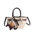 Schicke beige Beuteltasche mit braunen Griffen und dekorativen Anhängern für Damen - Mit Anhänger / Weiß