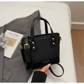 Detailansicht der schwarzen Lederhandtasche mit Goldnieten und Markenlogo von oben - Standardausführung / Schwarz