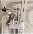 Chic cream leather tote bag with silver logo and adjustable straps in a lifestyle setting - 34*11*18 / Off White