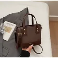 Detail of retro brown patchwork handbag with gold buckles and MIKAXIQI branding - With Pendant / Coffee