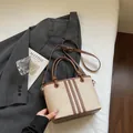 Chic beige canvas and brown leather bucket bag with top handles and adjustable strap - Off White