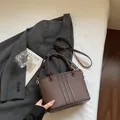 Deep brown lychee textured bucket bag with vertical stitching and gold hardware accents - Coffee