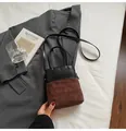 Chic two-tone bucket bag featuring black leather and brown quilted suede patchwork design - Brown